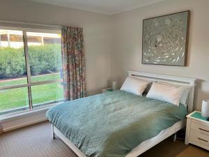 a bedroom with a bed and a large window at The Four CCCC's in Robe