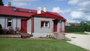 une maison rouge et blanche avec un toit rouge dans l'établissement Vana Postimaja Accommodation, à Suure-Jaani