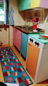a kitchen with a stove and a kitchen rug at The Secret Garden Maratea - Casa di Sery in Maratea