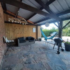 un patio con sofá y hamaca en Huize tinke en Tongeren