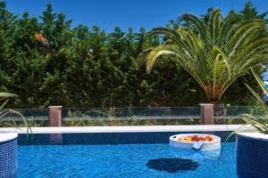 a swimming pool with a bowl of food in the water at Alexandra Golden Boutique Hotel-Adults Only in Chrysi Ammoudia