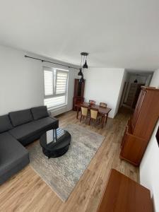 a living room with a couch and a table at Airport Warsaw Mokotow Luxury Apartment in Warsaw