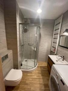a bathroom with a shower and a toilet and a sink at Airport Warsaw Mokotow Luxury Apartment in Warsaw
