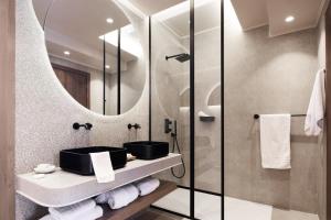a bathroom with a sink and a mirror at Alexandra Golden Boutique Hotel-Adults Only in Chrysi Ammoudia