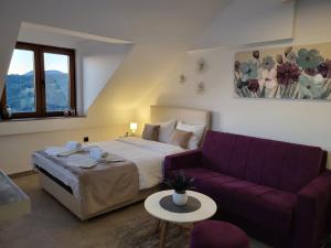 科帕奧尼克的住宿－Kloudscape Apartman Milmari Resort & Spa，一间卧室配有一张床和一张紫色沙发