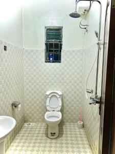 baño con aseo y lavabo y ventana en Pearl Sanctuary 02_Kisoro Homestay en Kisoro