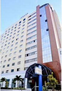 a large building with a sign in front of it at Loft no Condomínio Celita Franca Executive ApartHotel in Feira de Santana