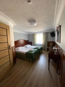 a hotel room with a bed and a desk at Hotel Kresowianka in Konin