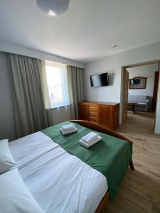 a bedroom with a large bed with two towels on it at Hotel Kresowianka in Konin