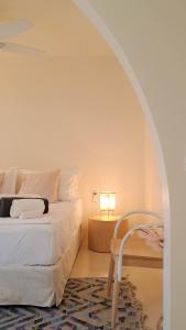 Un dormitorio con una cama y una mesa con una lámpara. en Nama Beach House, en rkadiko Chorio