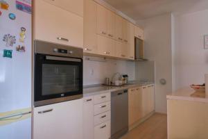 a kitchen with white cabinets and a stove top oven at Cosy apartment in Kumanovo in Kumanovo