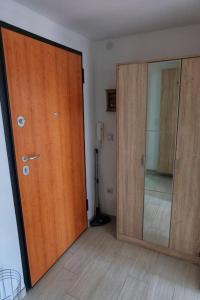 Cette chambre dispose d'une porte en bois et d'un miroir. dans l'établissement Cosy apartment in Kumanovo, à Kumanovo