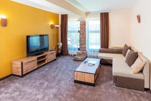 a living room with a couch and a flat screen tv at Mountain View Hotel Complex in Yabulkovets