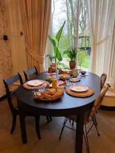 una mesa negra con platos y comida. en Pastorie Waaxens en Waaxens