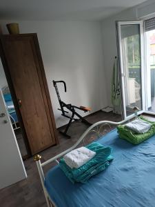 a bedroom with a bed with blue sheets and a treadmill at Apartma pri Renati in Celje