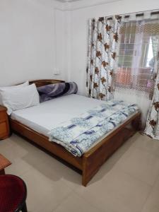 Bett in einem Zimmer mit Fenster in der Unterkunft Hotel Mon Valley in Tawang