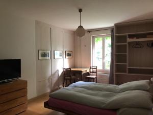 een slaapkamer met een bed, een tafel en een raam bij B&B Winterthur in Winterthur