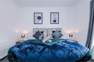un grande letto blu con un orsacchiotto sopra di Luxurious Living 2 BR Home MCR a Manchester