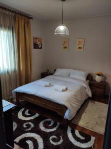 a bedroom with a large bed with white sheets at Spyros's Home in Tríkala +8 photos