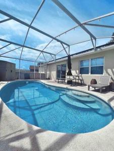 een groot blauw zwembad met een dak bij Modern 5 Beds Dog friendly Private Getaway! in Kissimmee