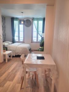 Una habitación con una mesa y un dormitorio con una cama. en Le Paséo, en Troyes 6 fotos más