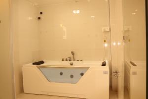 uma banheira branca na casa de banho com um chuveiro em Hotel Elegant Kathmandu Inn em Catmandu
