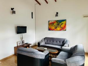 a living room with two couches and a table at Damithshouse in Bentota