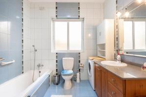 Gudja - Lovely 3 bedroom unit with own private entrance في Gudja: حمام مع مرحاض وحوض استحمام ومغسلة