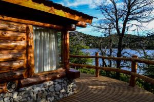 a cabin on a deck with a view of the water at El Rincon de Pehuenia in Villa Pehuenia