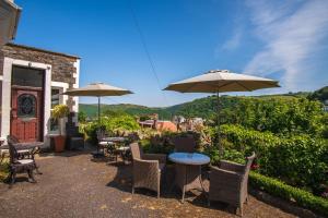 een patio met tafels, stoelen en parasols bij Rockvale House in Lynton