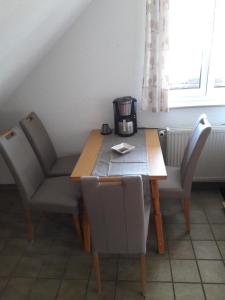 un tavolo con due sedie e una macchinetta del caffè. di Wunderschöne Ferienwohnung im Haus Schupp mit bester Aussicht a Wittenschwand
