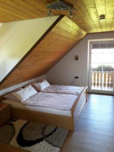 a bed in a room with a wooden ceiling at Wunderschöne Ferienwohnung im Haus Schupp mit bester Aussicht in Wittenschwand