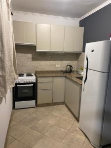 a kitchen with white cabinets and a white refrigerator at Departamento 3 centro - Cardiológico con cochera in Corrientes