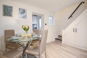 a dining room with a glass table and chairs at SPECIAL PROMO! Perfect Group Accommodation, 3 Bathrooms Perfect for Contractors and Businesses with relocation Requirement near Harwich Sea Port in Harwich