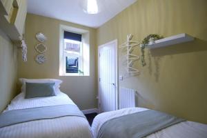 a bedroom with two beds and a window at Knightstone Apartment in Weston-super-Mare