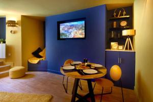 um quarto azul com uma mesa e algumas cadeiras em Knightstone Apartment em Weston-super-Mare