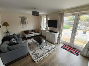 a living room with a couch and a tv at 3 bedroom townhouse near Bicester Village in Bicester