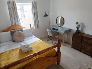 1 dormitorio con 1 cama con 2 toallas en 3 bedroom townhouse near Bicester Village, en Bicester