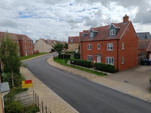 an empty street in a residential neighborhood with houses at 3 bedroom townhouse near Bicester Village in Bicester