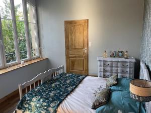 a bedroom with a bed and a dresser and windows at Appartement de caractère in Mirecourt