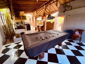 a living room with a pool table on a checkered floor at Uma Dewa homestay in Keramas
