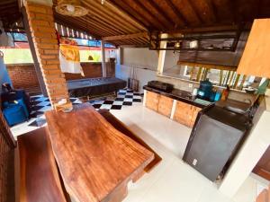 mit Blick auf eine Küche mit einem Holztisch in der Unterkunft Uma Dewa homestay in Keramas