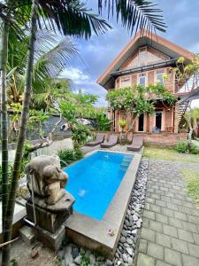a swimming pool in front of a house at Uma Dewa homestay in Keramas