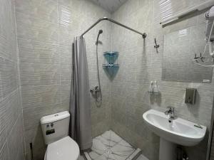 a bathroom with a toilet and a sink at Byond Hotel & Hostel in Tashkent