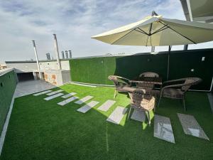 a patio with a table and chairs and an umbrella at Byond Hotel & Hostel in Tashkent