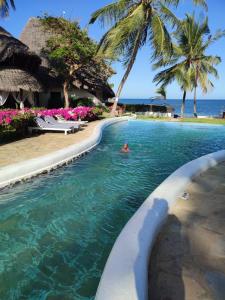 a person swimming in a swimming pool next to the ocean at Sophia house in Malindi