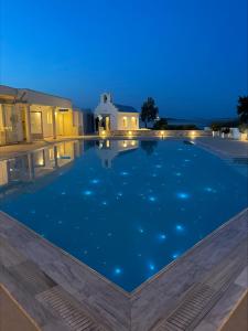 a swimming pool at night with stars in the water at Akti Naoussa Paros in Naousa