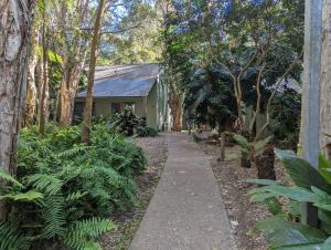 un camino que conduce a una casa con árboles y plantas en The Oasis at One Mile Beach, en Nelson Bay