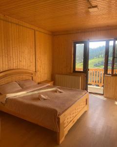 a bedroom with a bed and a large window at Panorama Bakhmaro in Bakhmaro