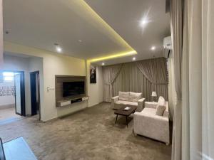 بريفير للأجنحة الفندقية Privere Hotel Suites في الرياض: غرفة معيشة مع أريكة وتلفزيون